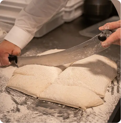 Bakker snijdt desemdeeg in porties